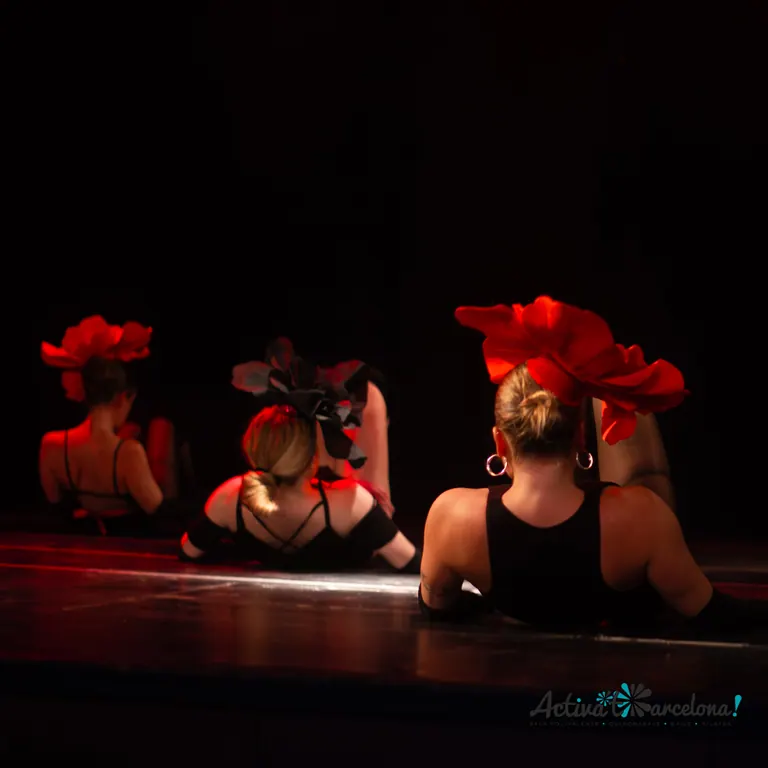 Cabaret dancers with red feather headdresses on stage