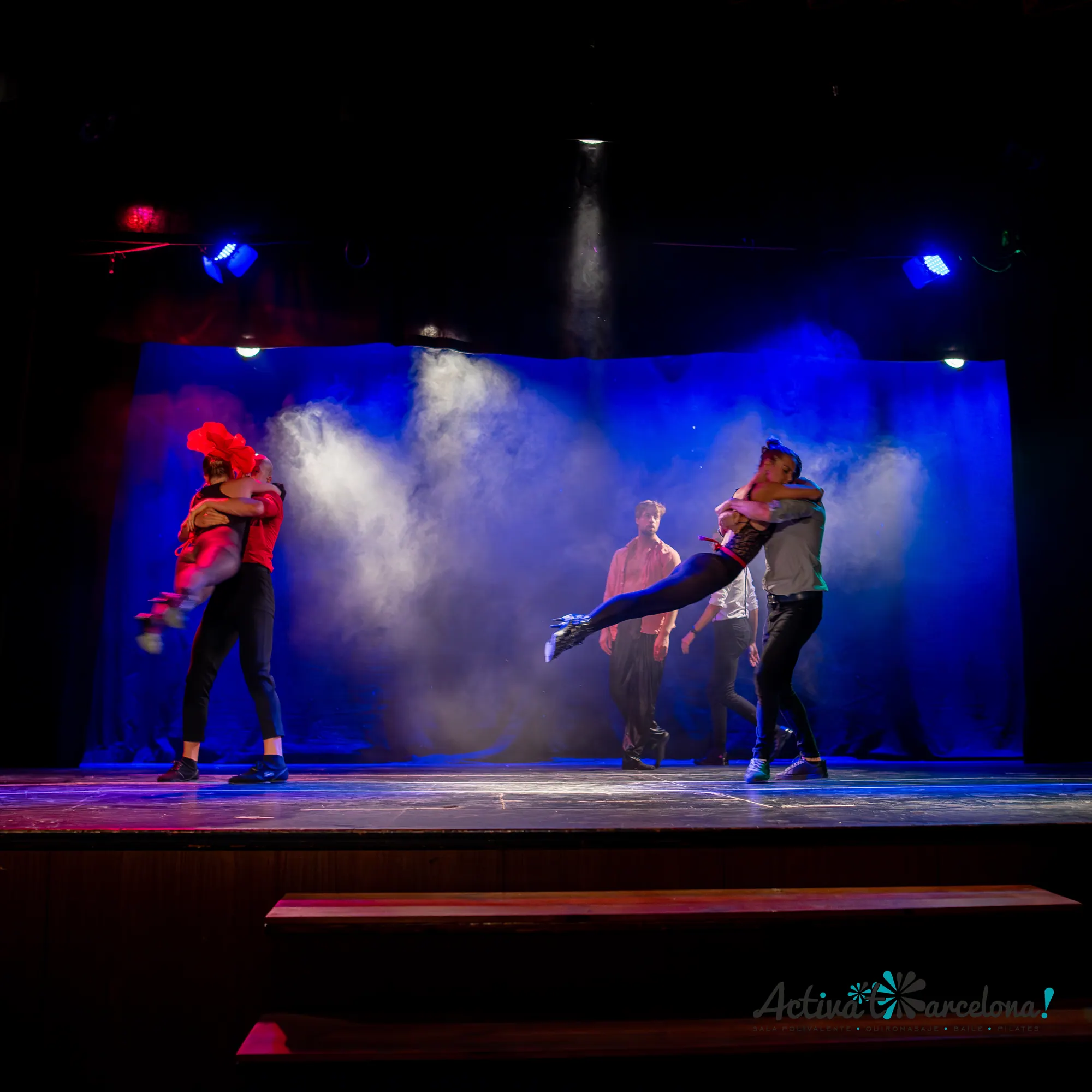 Dance duo lifting on a theatre stage with dramatic lighting